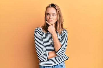 Beautiful blonde woman wearing casual clothes thinking concentrated about doubt with finger on chin and looking up wondering