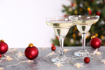 Beautiful christmas composition with two glasses of sparkling wine, decorations on textured table. New year's eve tradition to celebrate with champagne. Close up, copy space, background.