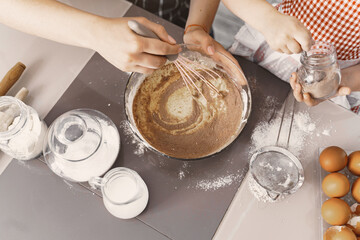 Family in a kitchen. Beautiful mother with little daughter. Woman in a black shirt.