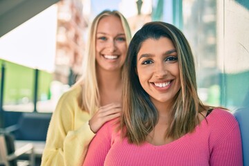 Two beautiful and young girl friends together having fun at the city