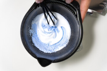 Hairdresser colorist kneads paint for hair dyeing. The concept of the salon barbershop. - obrazy, fototapety, plakaty