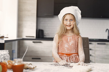 Little girl prepare the pie. Kid in the kitchen. Child with a flour.
