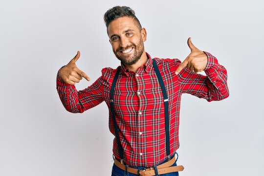 Handsome man with beard wearing hipster elegant look looking confident with smile on face, pointing oneself with fingers proud and happy.