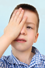 boy, kid, part of the face, covered one eye with a palm, vision test concept, diagnosis, treatment of ophthalmic diseases, eyelids, emotional development of children