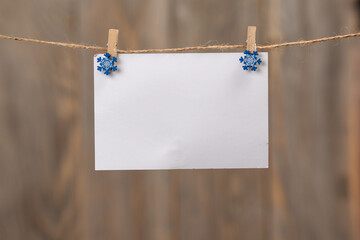 A blank paper for your text hanging on a string on a blurry background.