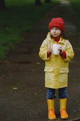 Kids in a puddle. Child having fun outdoors. Kid with tea and thermos.