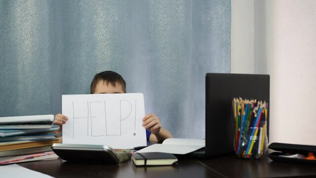 the boy shows a piece of paper with the inscription help. terribly difficult task.