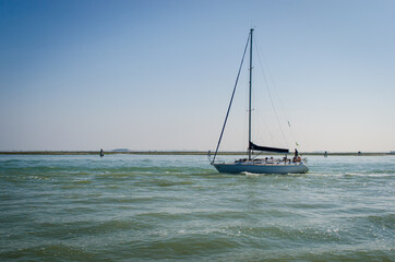 Barca a vela naviga a motore nella laguna di Venezia