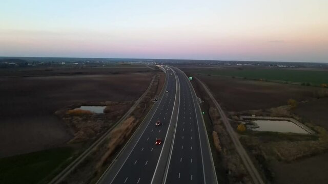 Aerial slide flyover traffic on highway after sun is going down in the evening.Drone footage.