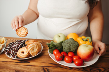 Obraz na płótnie Canvas Fat woman choosing between healthy and junk food