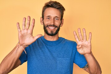 Handsome caucasian man with beard wearing casual clothes showing and pointing up with fingers number nine while smiling confident and happy.