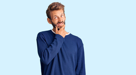 Handsome blond man with beard wearing casual sweater thinking worried about a question, concerned and nervous with hand on chin