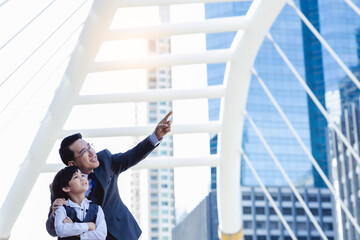 Business father showing heritage of building to his son that young boy will be heir. Little child...