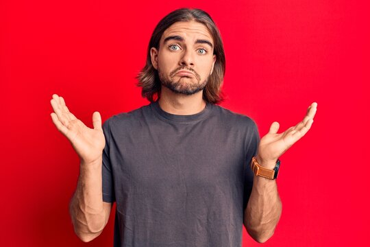 Young handsome man wearing casual clothes clueless and confused with open arms, no idea and doubtful face.