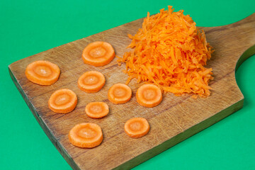 Carrots on a green background. Healthy eating. Shredded carrots next to chopped