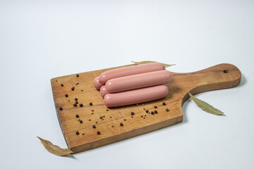 Sausages on a wooden board. Several sausages are on top of each other. meat product on a white background.
