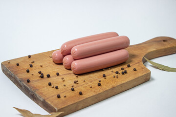 Sausages on a wooden board. Several sausages are on top of each other. meat product on a white background.