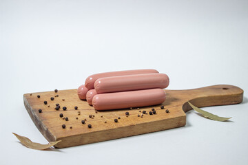 Sausages on a wooden board. Several sausages are on top of each other. meat product on a white background.