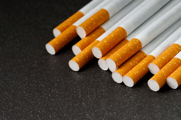 image of several commercially made cigarettes. pile on dark black. or Non smoking campaign concept,...