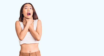 Fototapeta premium Young beautiful chinese girl wearing casual clothes shouting and suffocate because painful strangle. health problem. asphyxiate and suicide concept.