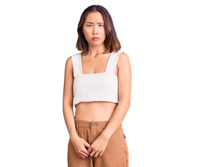 Young beautiful chinese girl wearing casual clothes skeptic and nervous, frowning upset because of...