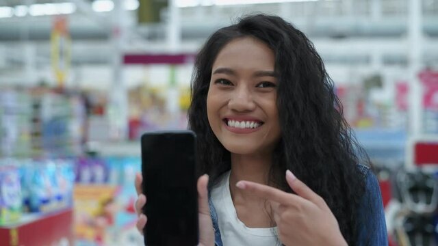Shopping concepts of 4k Resolution. Asian girls presenting their mobile program in the mall.