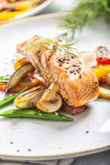 Grilled salmon, mushrooms and vegetables served on a plate