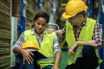 Young African female warehouse worker staff feeling sad and stress while Caucasian man consoling...