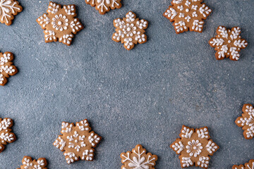 Christmas homemade gingerbread cookies in the shape of snowflakes and herringbone on a blue background. Holiday sweets for decoration and gifts.