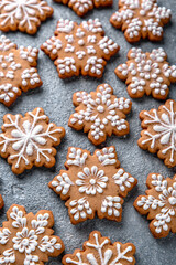 Obraz na płótnie Canvas Christmas homemade gingerbread cookies in the shape of snowflakes and herringbone on a blue background. Holiday sweets for decoration and gifts.