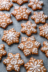 Christmas homemade gingerbread cookies in the shape of snowflakes and herringbone on a blue background. Holiday sweets for decoration and gifts.