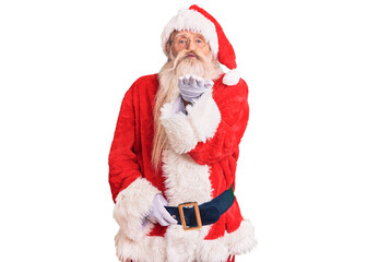 Old senior man with grey hair and long beard wearing traditional santa claus costume looking at the camera blowing a kiss with hand on air being lovely and sexy. love expression.