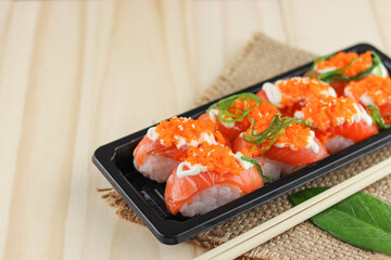 Salmon sushi on wooden background, Japanese style, Slices of raw salmon fillet, Copy space.