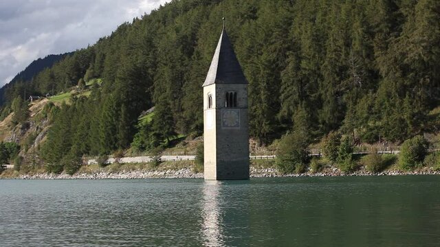 The Curon bell tower that emerge from lake Resia and reflected itself on waters, South Tyrol, Italy