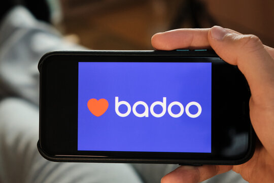 Badoo application on the smartphone in mans hand. Man laying and using application for dating and meeting. Social network concept, July 2020, Prague, Czech Republic.