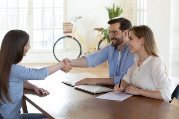 Smiling diverse recruiters handshake female job candidate or applicant get acquainted at interview....