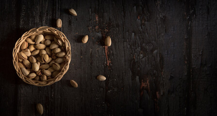 Pistachio in basket on a dark wooden background