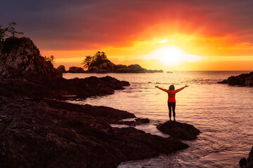 Wild Pacifc Trail, Ucluelet, Vancouver Island, BC, Canada. Adventurous Girl Enjoying the Beautiful View of the Rocky Ocean Coast. Colorful Sunset Sky. Concept: Travel, adventure, freedom