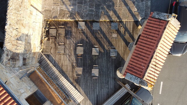 Vista a&eacute;rea cenital de una terraza de madera con mesas y sillas y un h&oacute;rreo gallego
