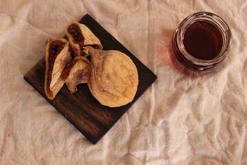 composition of dried figs on a wooden plate and brown background. overhead. space for text.