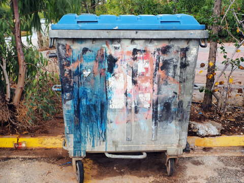 Colourful graffiti on a grey rubbish bin on a street