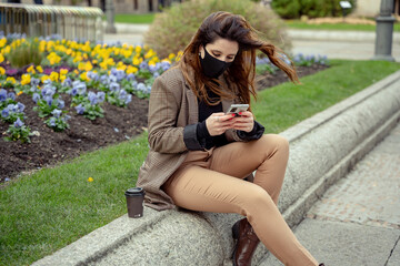 Girl watching a phone wearing a mask with flower background