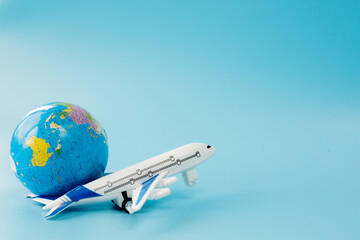 Airplane and globe on blue background. Summer or vacation concept. Copy space