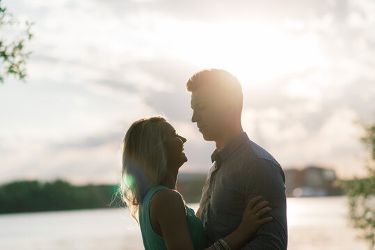 Silouette, loving couple on the lake during sunset. Golden hour