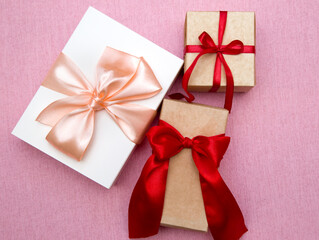 gift boxes with bows on a pink background. Flat lay