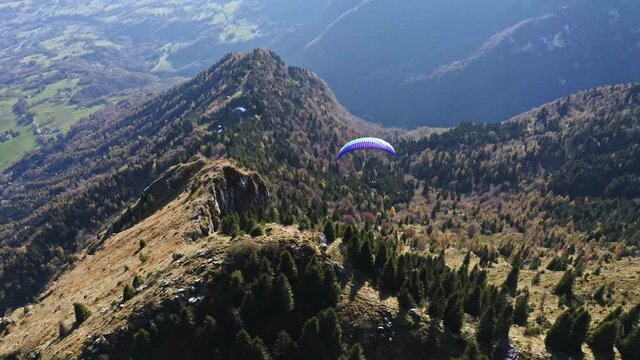 colorful paraglider turns left in the air, adventure sport aerial on dolomites