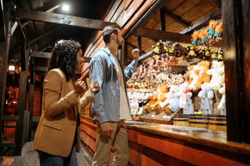 Love couple playing darts in amusement park
