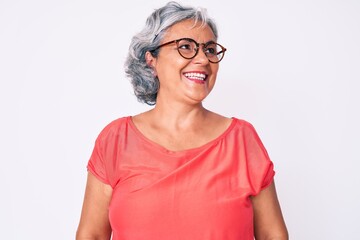 Senior hispanic grey- haired woman wearing casual clothes and glasses looking away to side with...