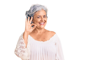 Senior woman with gray hair wearing bohemian style smiling positive doing ok sign with hand and fingers. successful expression.