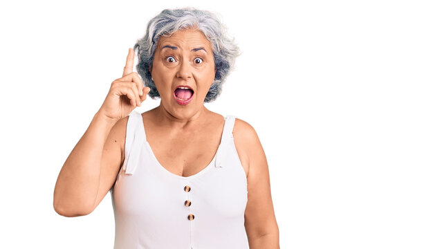 Senior woman with gray hair wearing casual clothes pointing finger up with successful idea. exited and happy. number one.